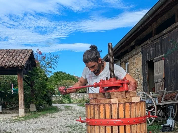 Romain presse les raisins des Mauvaises Herbes dans un pressoir traditionnel à Vourey